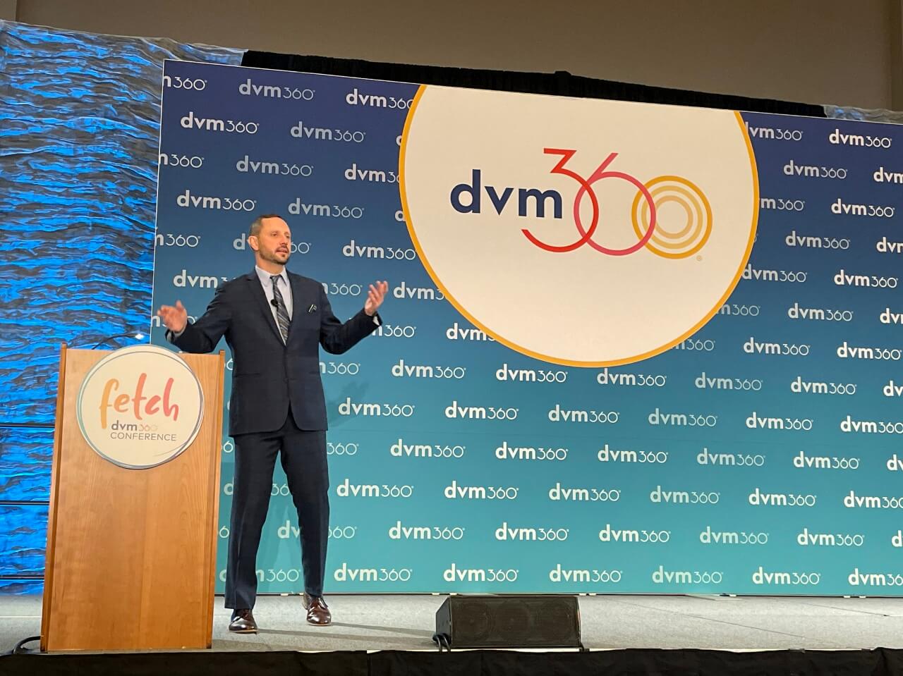 Matthew Brunke, DVM stands at a podium on stage at dvm360's Fetch San Diego 2021 conference